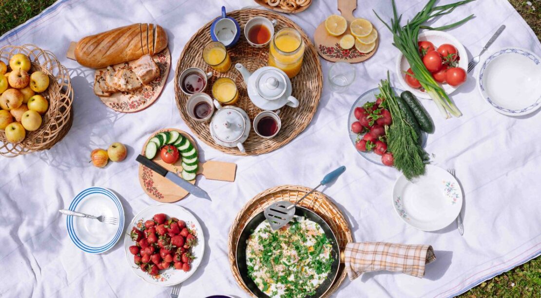 Imagen de un picnic primaveral en el que se encuentran varios alimentos.